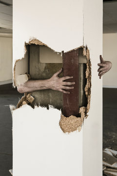 Man's hand around broken pillar