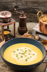 Pumpkin cream soup. Homemade fresh pumpkin cream soup served with croutons on a rustic background, autumn decoration