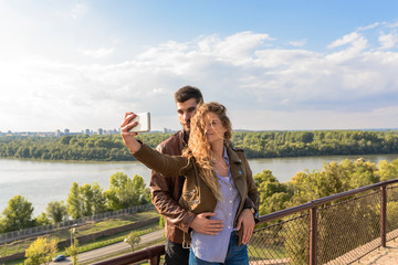 Fototapeta na wymiar Attractive long haired woman taking selfie with her handsome boyfriend