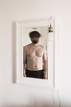 Un homme torse nu dans le miroir