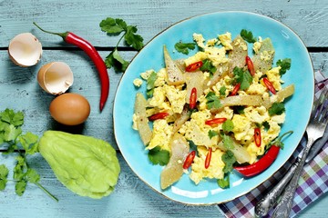 egg chayote in mexican style. whipped eggs are fried with chopped chayote with cilantro and spicy chili. recipe with chayote. top view. Mexican food
