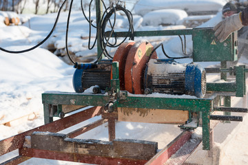 Sawing boards on the sawmill. Cook lumber in winter. Work on the sawmill.