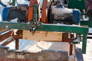 Sawing boards on the sawmill. Cook lumber in winter. Work on the sawmill.