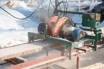 Sawing boards on the sawmill. Cook lumber in winter. Work on the sawmill.