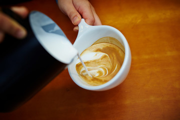 hand holding cup of coffee on black background