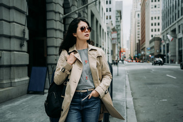 portrait of stylish smiling happy asian woman walking in street san francisco usa. attractive summer fashion trend traveler with sunglasses walking in busy business area in city urban in cloudy day