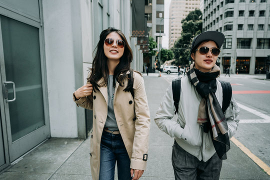 group of young women travelers walking on street with sunglasses smiling. two happy female friends sightseeing in san francisco going to next tourist spot famous attraction in spring holidays.