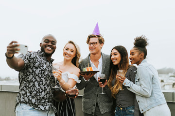 Diverse group of friends taking a selfie at a birthday party