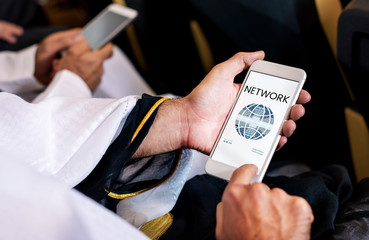 Hands working on digital device network graphic overlay