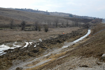 Drainage water channel along the highway. Canal for draining water along the highway