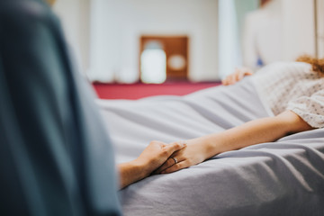 Nurse holding her patients hand