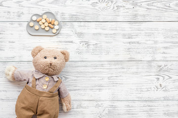 Childhood diseases concept. Treatment of children.Teddy bear toy and pills on white wooden background top view copy space