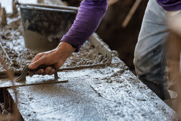 Plasterer concrete cement work. using a trowel to smooth or leveling concrete slab floor work step of the building construction.