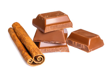 Tasty milk chocolate closeup with cinnamon sticks isolated on white background