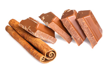 Tasty milk chocolate closeup with cinnamon stick isolated on white background