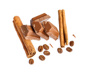 Tasty milk chocolate closeup with grains of coffee and cinnamon sticks isolated on white background