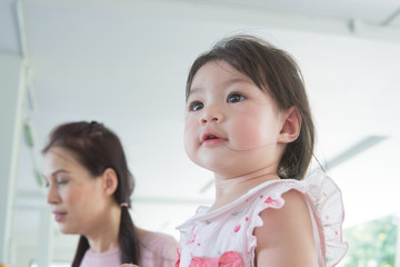 Asian baby girl playing in the park with mother's support.