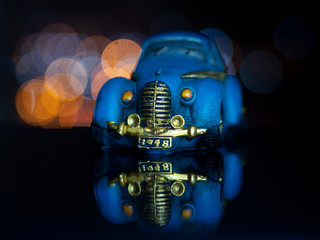 Blue toy car on a black background.Beautiful bokeh.