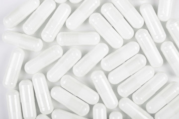 White pills on white background. Texture.
