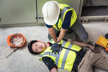 Start Compressions using both hands - 30 times, Life-saving and rescue methods. Accident at work of electrician job or Maintenance worker in the control room of factory. - obrazy, fototapety, plakaty