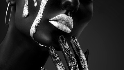 Young woman face with art fashion makeup. An amazing model with creative makeup. Black and white closeup portrait