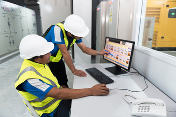 Electrical engineering with inspector while training and recording in operation of power in the plant for production process, routine daily record. Focusing on foreground people learning concept.
