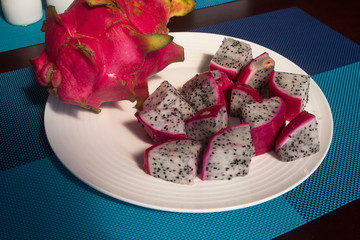 dragon fruit slices and whole lie on a plate on the table