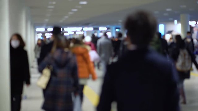 Unrecognizable Anonymous Crowd of Japanese Commuters Walking in Train Station Wearing Jackets During Winter