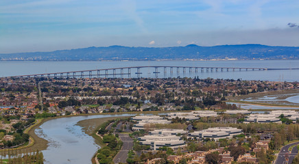 Aerial view from an airplane of San Mateo Hayward bridge across the San Francisco Bay and Foster...