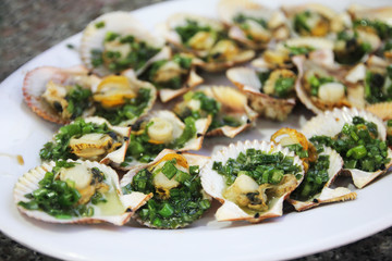 Grilled scallops with herbs on a plate.