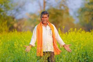 Indian farmer at black mustard field