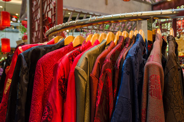 Colorful traditional chinese costumes hanging for sale during Chinese New Year.