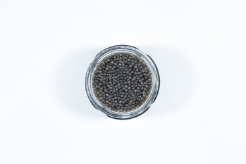 Black caviar in a bowl on a white background. High price