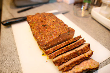 Woman hands cutting piece of meatloaf, she prepare for tasting of food at kitchen. Chef cutting meatloaf with knife on board on restaurant kitchen table. Housewife sliced meatloaf on cutting board.