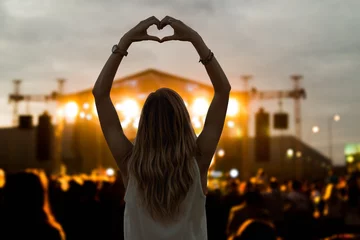 Foto op Plexiglas Girl with heart-shape symbol enjoying her favorite group on the concert. © astrosystem