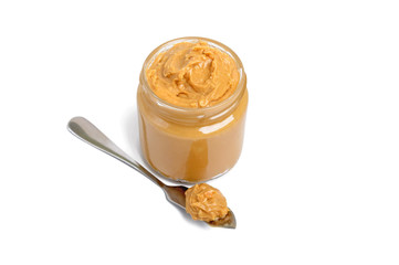 Peanut butter in a glass jar isolated on white background.  A traditional product of American cuisine.