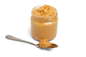 Peanut butter in a glass jar isolated on white background.  A traditional product of American cuisine.