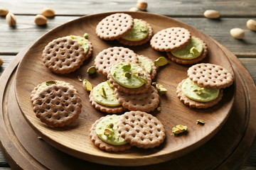 Tasty pistachio cookies on wooden plate