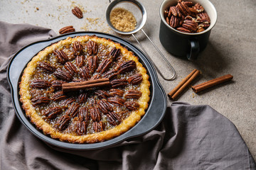 Pan with tasty pecan pie on grey table