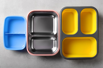 Empty school lunch boxes on grey background