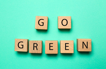 Wooden cubes with text GO GREEN on color  background