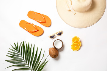 Fototapeta na wymiar Female beach accessories with tropical fruits and leaf on white background