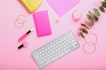 Composition with keyboard, beauty accessories and cosmetics on color background