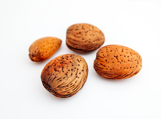 A pile of wild peeled almond nuts, closeup, isolated on white background.