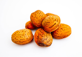 A pile of wild peeled almond nuts, closeup, isolated on white background.