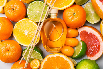 Reed diffuser and different citrus fruits on table