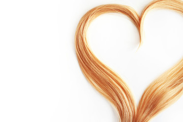 strand of blond hair isolated on white. Curls of hair in the shape of a heart