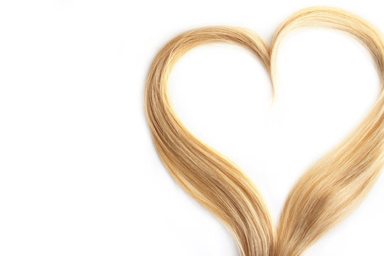 strand of blond hair isolated on white. Curls of hair in the shape of a heart