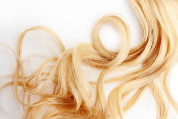 Golden Curls hair isolated on white background. strand of Blonde or red hair, hair care