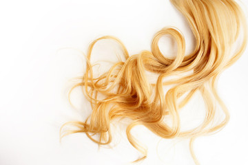 Golden Curls hair isolated on white background. strand of Blonde or red hair, hair care